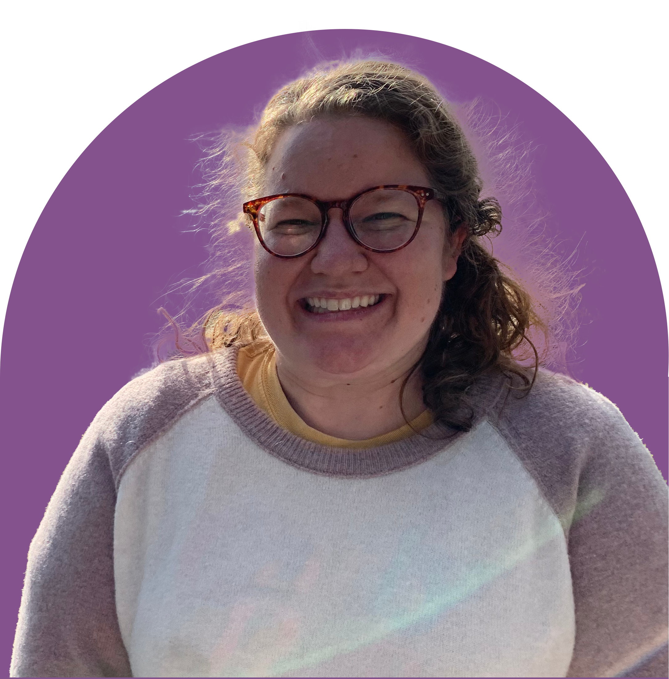 A picture of a white woman with brown hair wearing glasses, smiling at the camera.